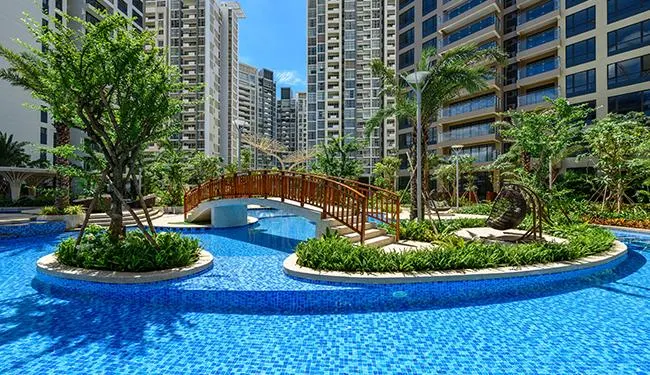 Hồ bơi cảnh quan với cầu gỗ giữa các tòa tháp Estella Heights