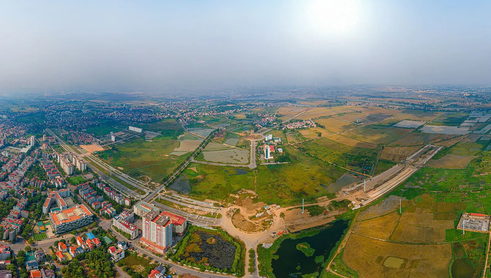 Khu đất dự án nhìn từ phía khu dân cư, nhà cửa và đường phố ở tiền cảnh